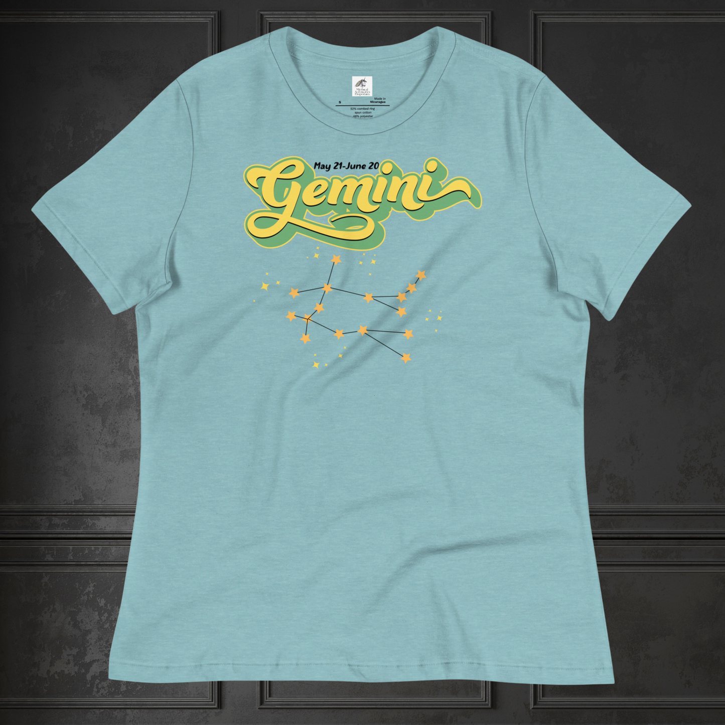 Front view of flat lay heather blue lagoon women's Gemini Tee. This Astrology T-Shirt has the word Gemini in large lemon yellow script shadowed in bright green for a 3-D effect. Above this it Says May 21-June 20. Under Gemini is the star constellation with yellow stars connected by a black line and yellow smaller stars surrounding this. The perfect May or June Birthday Gift for Her or yourself.