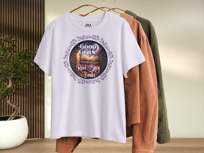 Lavender Women's Graphic Tee on Hanger, front view. Graphic has a purple floral frame around the circle graphic. The graphic has a botanical feel surrounding a stack of magic books with the top book open with light emanating from the book. A candle is lit nearby and a starry sky with a crescent moon is above the books. Above the books it states "Good Girls". Below the books it states "Read Spicy Books".