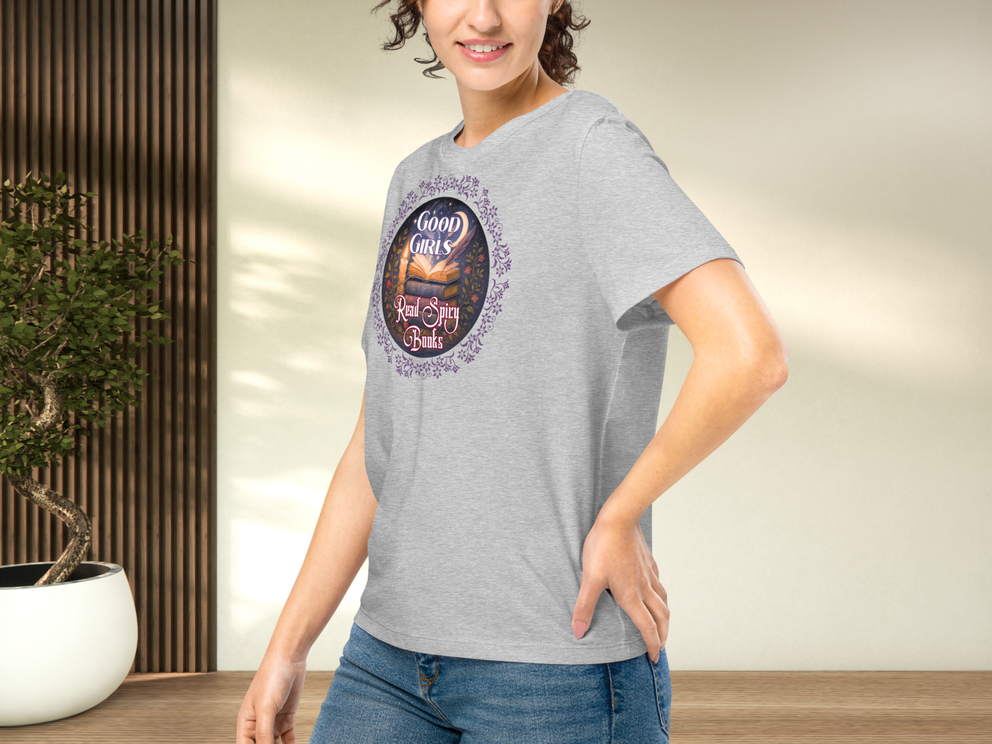 Model wearing a women's Romantasy Graphic Tee in Athletic Grey, left side view. Models arm is on hip and you can see the side seam, the graphic, the front of the collar, and that the sleeve comes to the mid point of the upper arm.