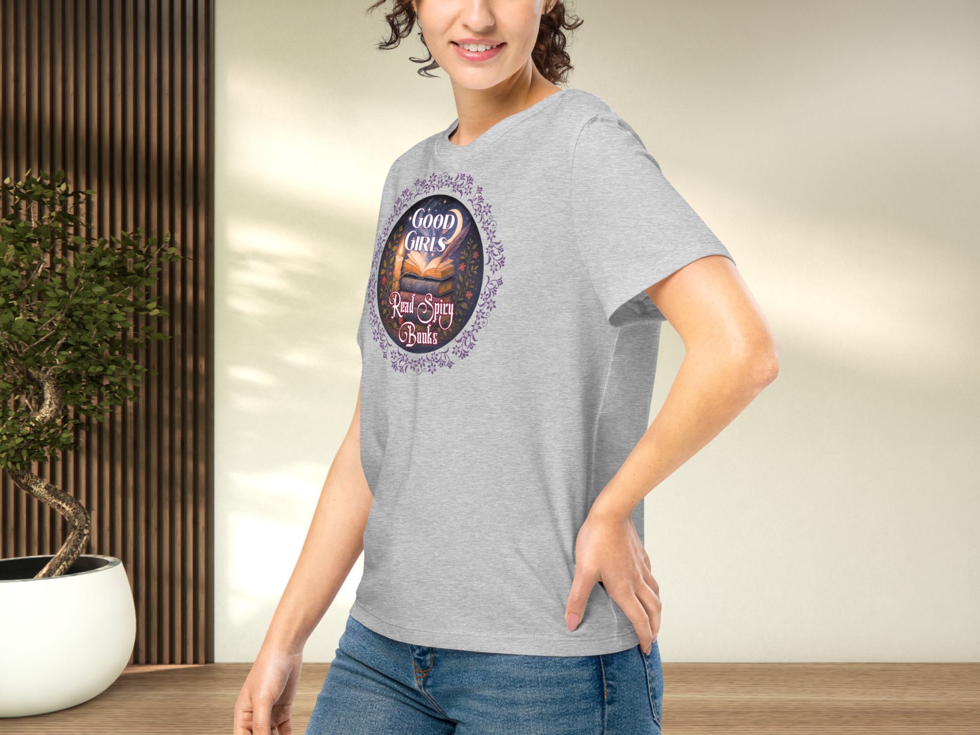 Model wearing a women's Romantasy Graphic Tee in Athletic Grey, left side view. Models arm is on hip and you can see the side seam, the graphic, the front of the collar, and that the sleeve comes to the mid point of the upper arm.