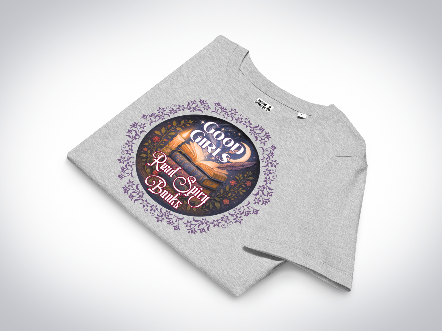Women's Romantasy Graphic Tee in Athletic Grey folded, front view. Graphic has a purple floral frame around the circle graphic. The graphic has a botanical feel surrounding a stack of magic books with the top book open with light emanating from the book. A candle is lit nearby and a starry sky with a crescent moon is above the books. Above the books it states "Good Girls". Below the books it states "Read Spicy Books".