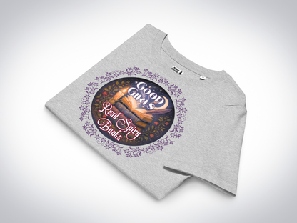 Women's Romantasy Graphic Tee in Athletic Grey folded, front view. Graphic has a purple floral frame around the circle graphic. The graphic has a botanical feel surrounding a stack of magic books with the top book open with light emanating from the book. A candle is lit nearby and a starry sky with a crescent moon is above the books. Above the books it states "Good Girls". Below the books it states "Read Spicy Books".