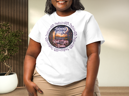 Curvy model wearing a women's Romantasy Graphic Tee in white, front view. Graphic has a purple floral frame around the circle graphic. The graphic has a botanical feel surrounding a stack of magic books with the top book open with light emanating from the book. A candle is lit nearby and a starry sky with a crescent moon is above the books. Above the books it states "Good Girls". Below the books it states "Read Spicy Books".