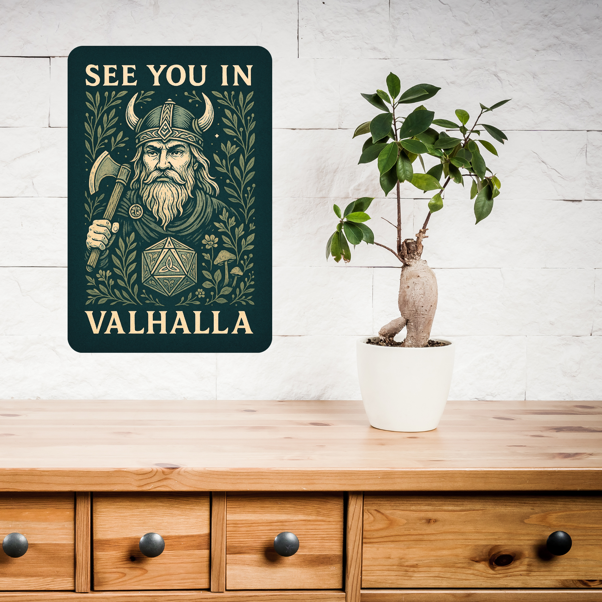 Metal  Wall Poster 8x12 hanging above a console or wooden buffet. Dark green Metal Sign with graphic in light golden browns. Bearded Viking wearing a horned helmet and holding an axe over his shoulder. D20 with symbols instead of numbers below the Viking. Botanical Design surrounding the image with mushrooms, vines, and flowers. At the top of the wall art it says, "See You In". At the bottom of the home decor, "Valhalla".  Fantasy Gaming Book Lover's Gift