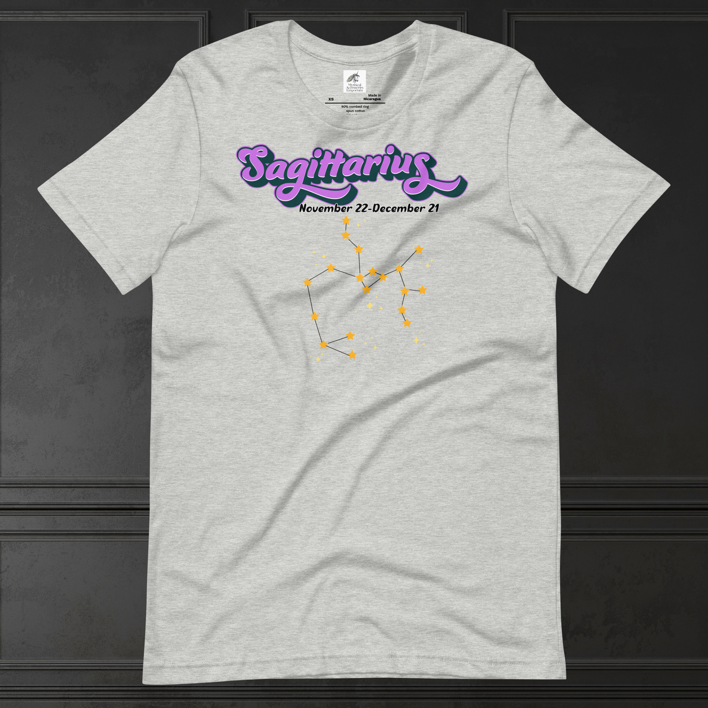 Front view of flat athletic heather (grey) men's Sagittarius Tee. This astrology T-Shirt has the word Sagittarius in large purple script shadowed in black for a 3-D effect. Below this it Says November 22-December 21. Under Sagittarius is the zodiac star constellation with yellow stars connected by a black line and lighter yellow smaller stars surrounding this. The perfect December or November Birthday Gift for him or yourself.
