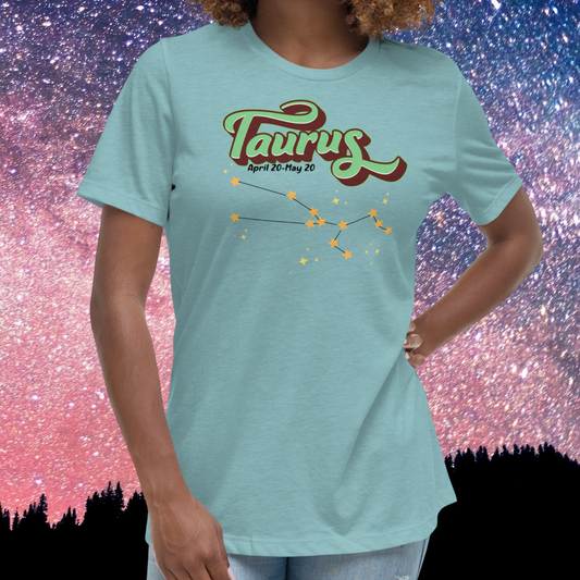 Front view of model wearing  heather blue lagoon women's Taurus Tee. This Astrology T-Shirt has the word Taurus in large leaf green script shadowed in deep brown for a 3-D effect. Below this it Says April 20-May 20. At the bottom is the star constellation for Taurus with yellow stars connected by a black line and  smaller stars surrounding the constellation. The perfect April or May Birthday Gift for Her or yourself.