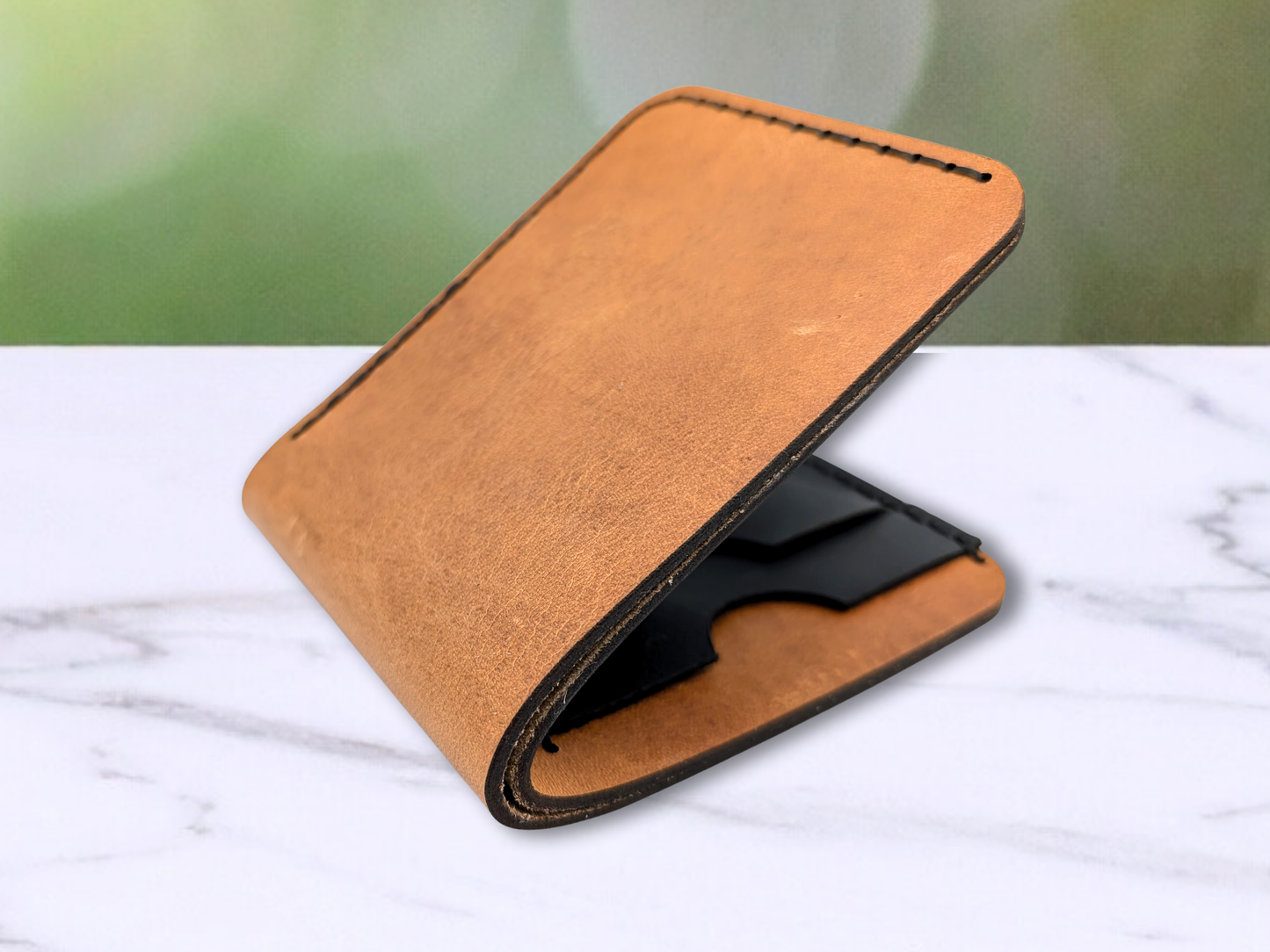 Bi Fold dad leather wallet handmade from veg tan leather with dark stitching. Folded and slightly open to see the dark stitching, dark edges, and a peek of the black leather card pockets. 