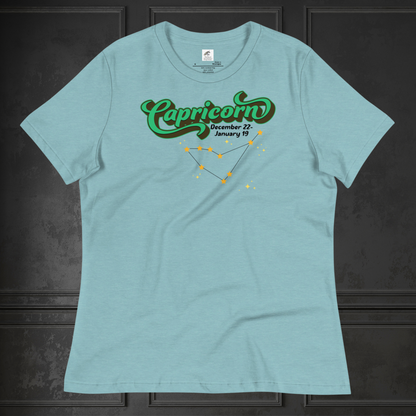 Front view of flat heather blue lagoon women's Capricorn Tee. This astrology T-Shirt has the word Capricorn in a large green script shadowed in black for a 3-D effect. Below this it Says December 22-January 19. Under Capricorn is the zodiac star constellation with yellow stars connected by a black line and lighter yellow smaller stars surrounding this. The perfect December or January Birthday Gift for Her or yourself.