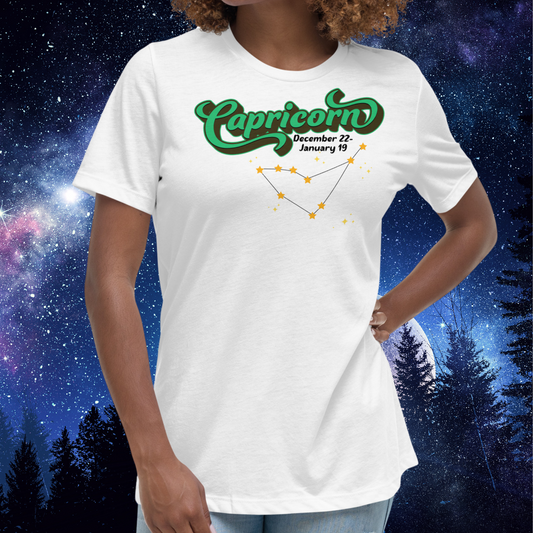Front view of model wearing white women's Capricorn Tee. This astrology T-Shirt has the word Capricorn in a large green script shadowed in black for a 3-D effect. Below this it Says December 22-January 19. Under Capricorn is the zodiac star constellation with yellow stars connected by a black line and lighter yellow smaller stars surrounding this. The perfect December or January Birthday Gift for Her or yourself.