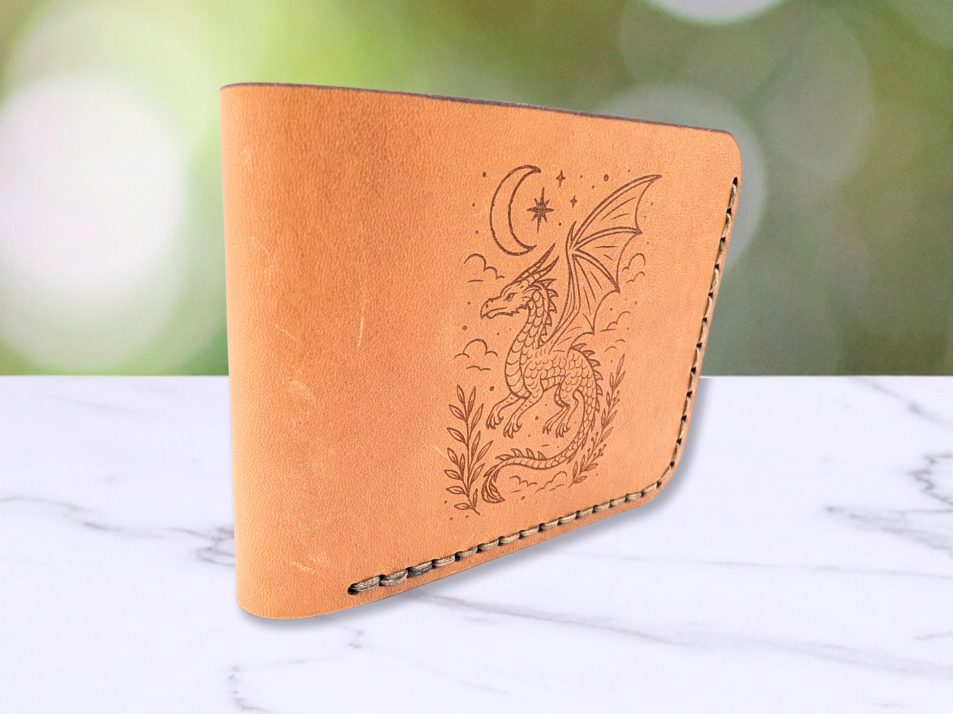 This is a view of the wallet standing on it's side. You are looking at the wallet from the folded leather side. You can see the dragon engraving on the bifold dad style wallet and the stitching of the handcrafted wallet is visible. Here you get an idea of the smooth feel of the leather and it's rich natural tones that vary. 