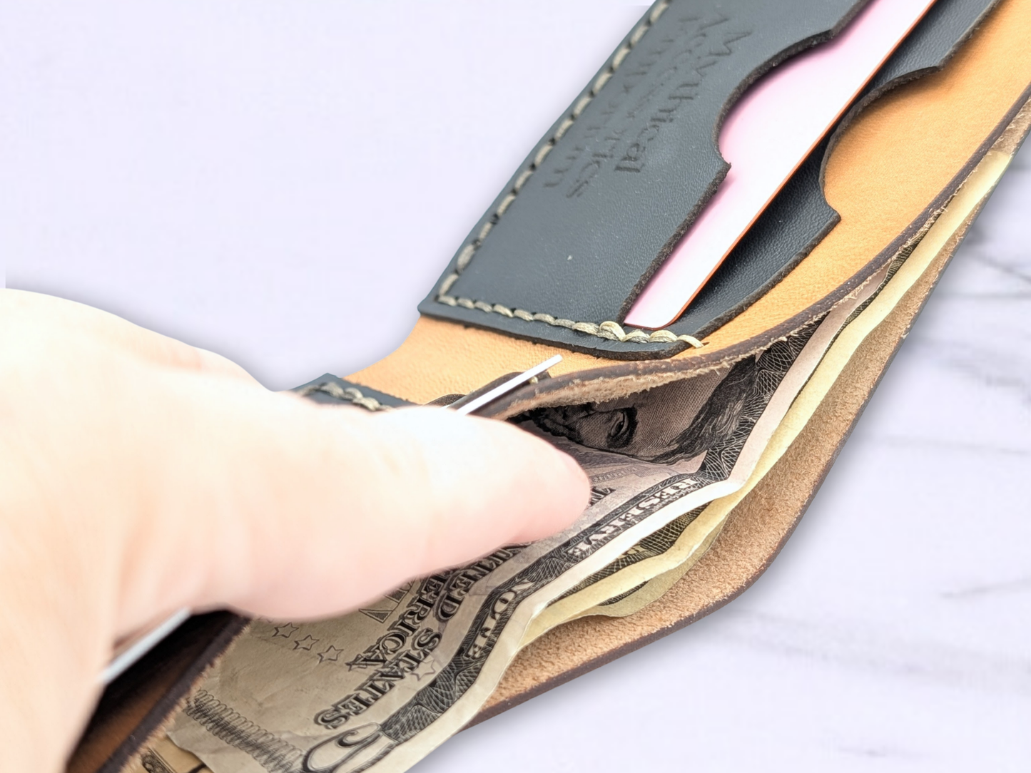 Be fold dragon wallet opened to view the interior of the cash compartment to see the suede interior. There are bills inside the cash compartment to see how they are held flat inside.