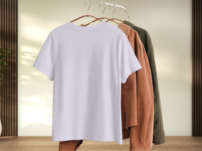Back view of white graphic t-shirt on a hanger with other clothing items in the background