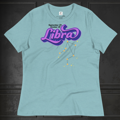 Front view of flat heather blue lagoon women's Libra Tee. This astrology Libra T-Shirt has the word Libra in large purple script shadowed in deep blue for a 3-D effect. Below this it Says September 23-October 22. Under Libra is the zodiac star constellation with yellow stars connected by a black line and lighter yellow smaller stars surrounding this. The perfect October or September Birthday Gift for Her or yourself.