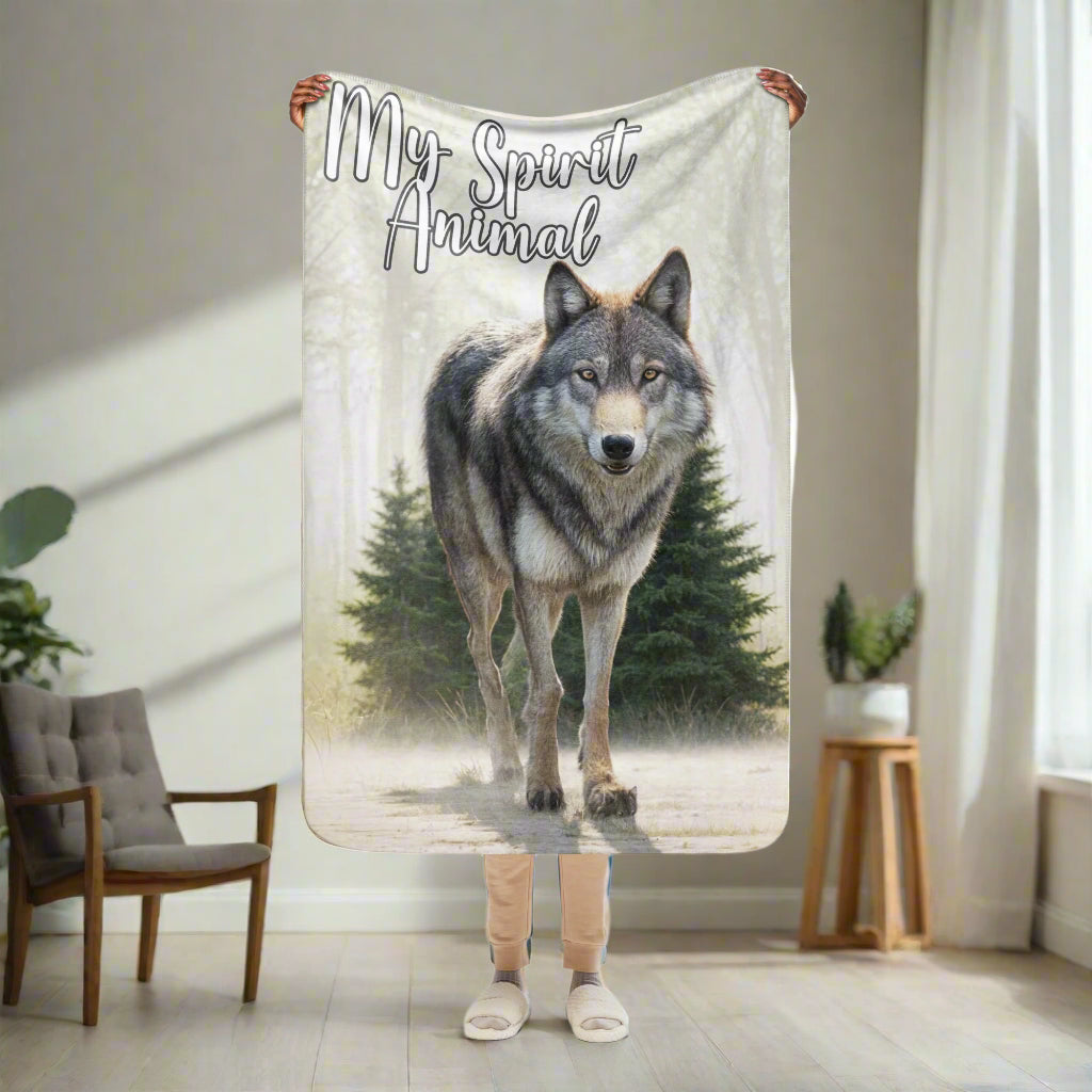 Wolf Women's Sherpa BLanket My Spirit Animal. Front view  held up by model, 37"x57". This is a child size blanket, a travel blanket, or perfect for a chilly office. A grey timberwolf gazes at you from the forest. Timber Wolf Shamanic Totem Animal, Mythical Accessories Emporium.