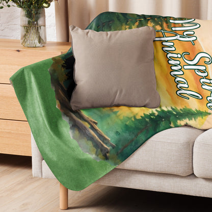 My Spirit Animal bear sherpa blanket.  Front view laying across the back and arm of a couch.  Grizzly Bear paused in front of logs walking through the forest framed in a sunset. My Spirit Animal text at the top in white script.