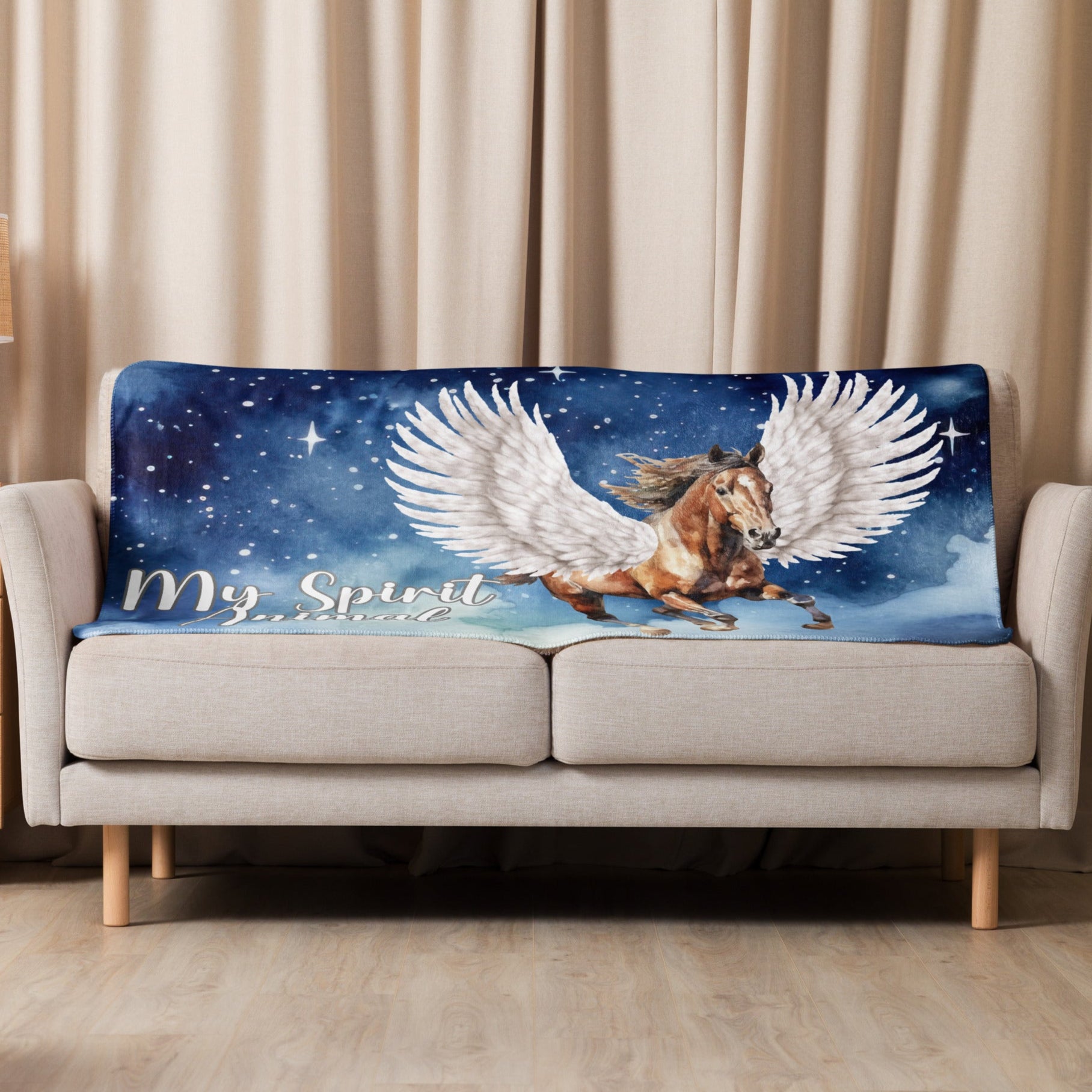 My Spirit Animal Pegasus Sherpa blanket. Laying over the back of a couch. Pegasus white feathered wings on a Pinto with a dark brown mane and tail, galloping through the sky against a background of clouds and stars. Mythical Accessories