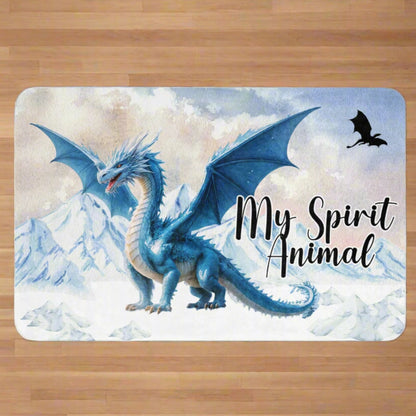 My Spirit Animal Dragon Blanket. Front view spread out on wood surface.  Blue Ice Dragon with wings spread standing in front of snow capped mountain range with a dragon silhouette flying above within a blue grey circle. Ice Dragon Fantasy Bookish Gift, Dungeons and Dragons DND Dungeon Master Gift, Fantasy Home Decor