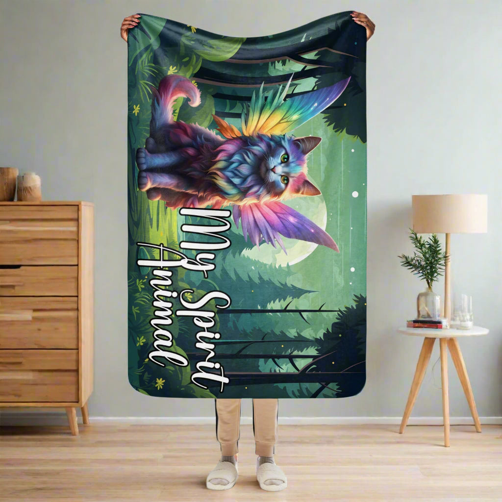 My Spirit Animal Fairy Cat sherpa blanket. Front view held up by a model, size 37x57, comes to models knees with arms above her head. Rainbow Fae Persian Cat wings spread behind her, tail curling to the right. Framed  in golden magic symbols. My Spirit Animal under the fairy cat in blue outlined in dark grey.