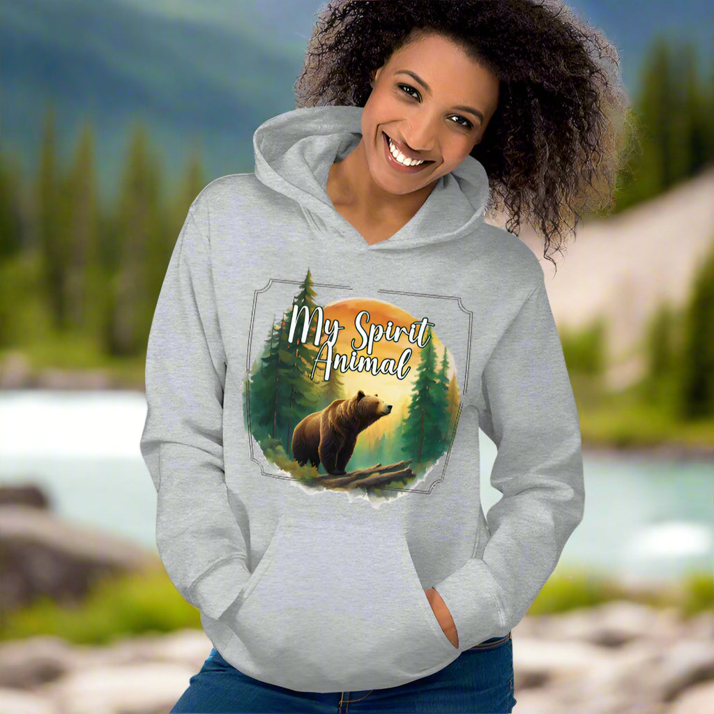 My Spirit Animal bear women's hoodie. Front view model facing front sport grey hoodie.  Grizzly Bear paused in front of logs walking through the forest framed in a sunset. My Spirit Animal text at the top in white script.