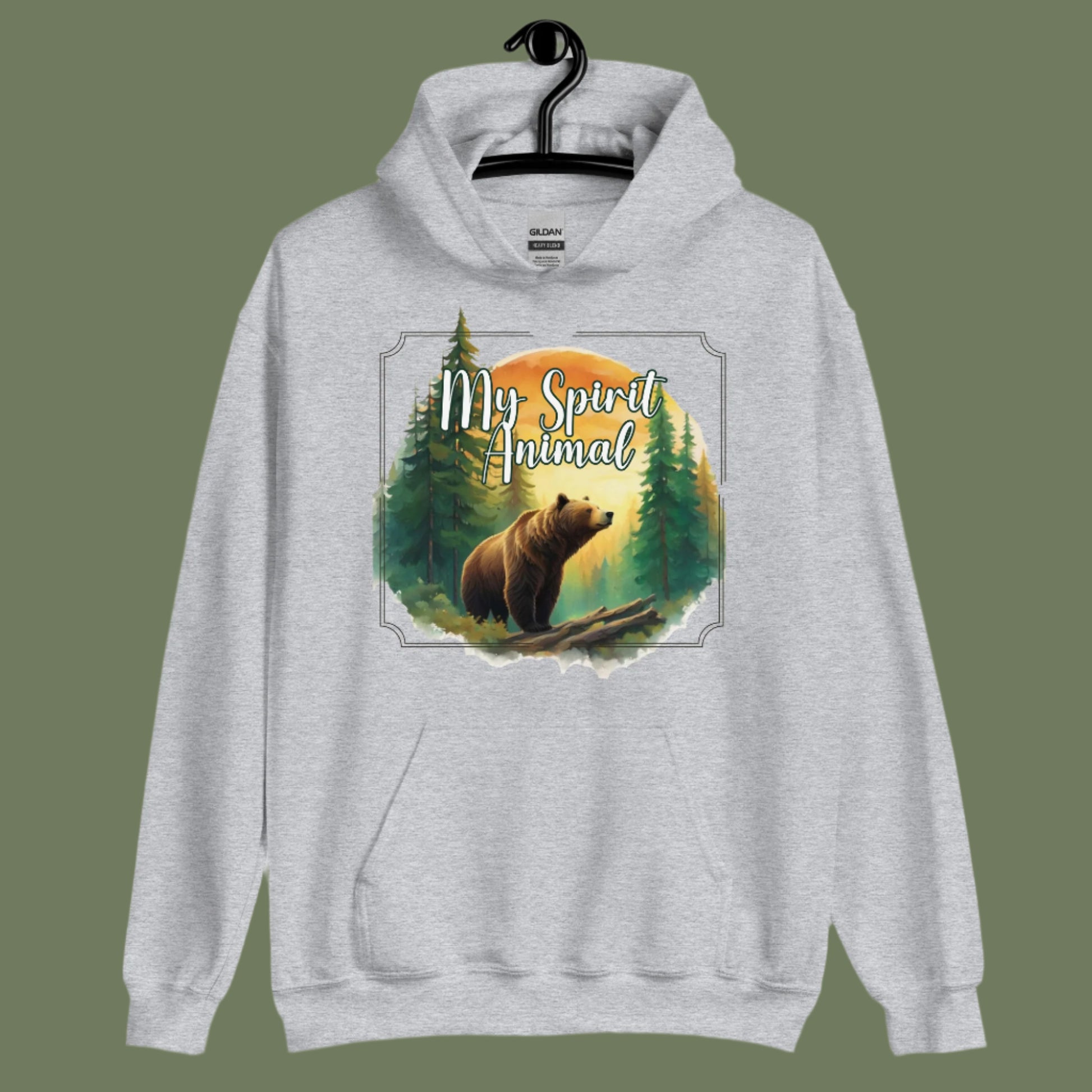 My Spirit Animal bear women's hoodie. Front view on hanger sport grey hoodie.  Grizzly Bear paused in front of logs walking through the forest framed in a sunset. My Spirit Animal text at the top in white script.