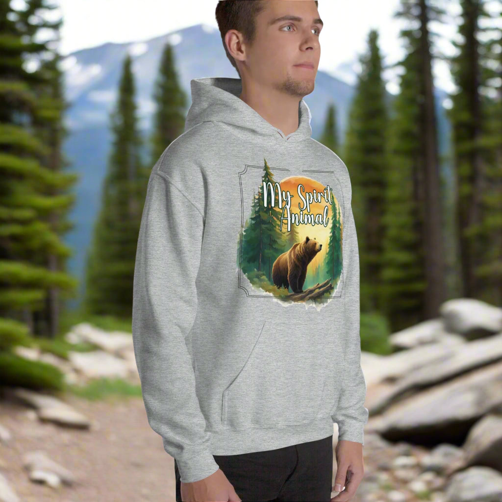 My Spirit Animal bear men's graphic hoodie. Front right view sport grey hoodie.  Grizzly Bear paused in front of logs walking through the forest framed in a sunset. My Spirit Animal text at the top in white script. Mythical Accessories