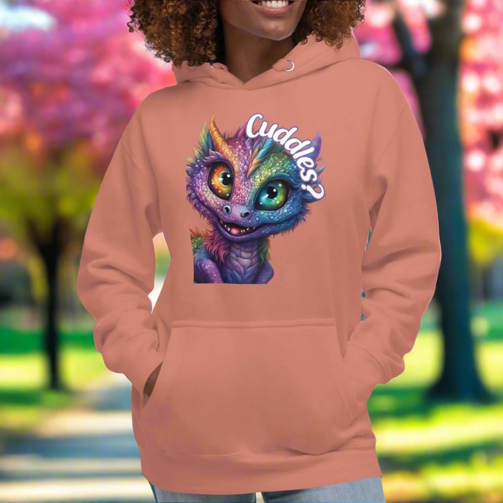 Dusty Rose Women's Hoodie Front View. Purple cross eyed baby dragon. Text above dragon circling head "Cuddles?". 