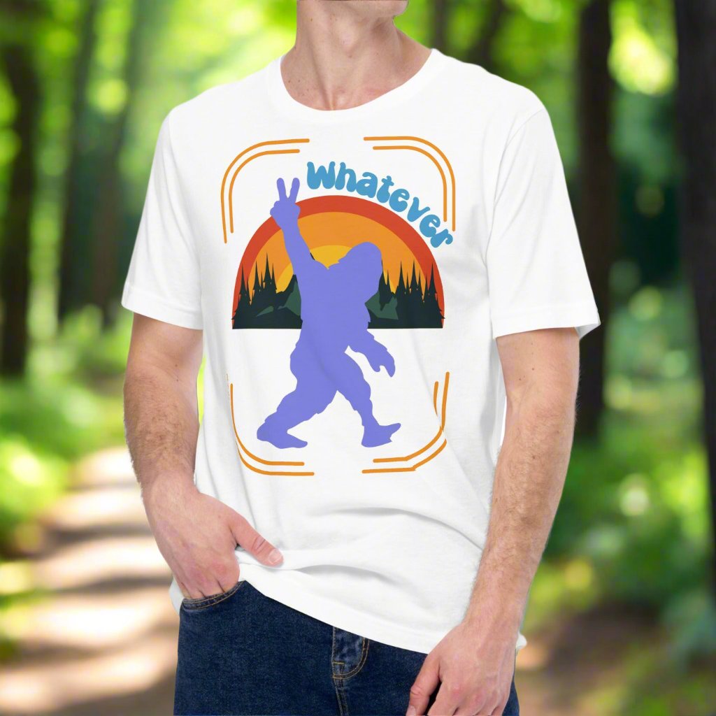 white big foot men's shirt front view. Purple big foot showing a peace sign against mountains, forest, and a rainbow. Above this is the text whatever. Vintage 80s feel and colors