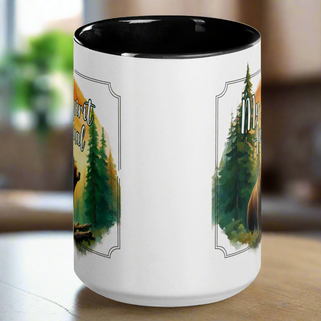 My Spirit Animal bear ceramic mug. Black interior and handle with handle to the back.  Grizzly Bear paused in front of logs walking through the forest framed in a sunset. My Spirit Animal text at the top in white script.