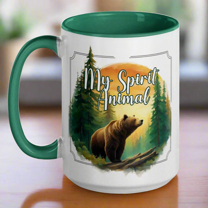 My Spirit Animal bear ceramic mug. Green interior and handle with handle to the left.  Grizzly Bear paused in front of logs walking through the forest framed in a sunset. My Spirit Animal text at the top in white script.