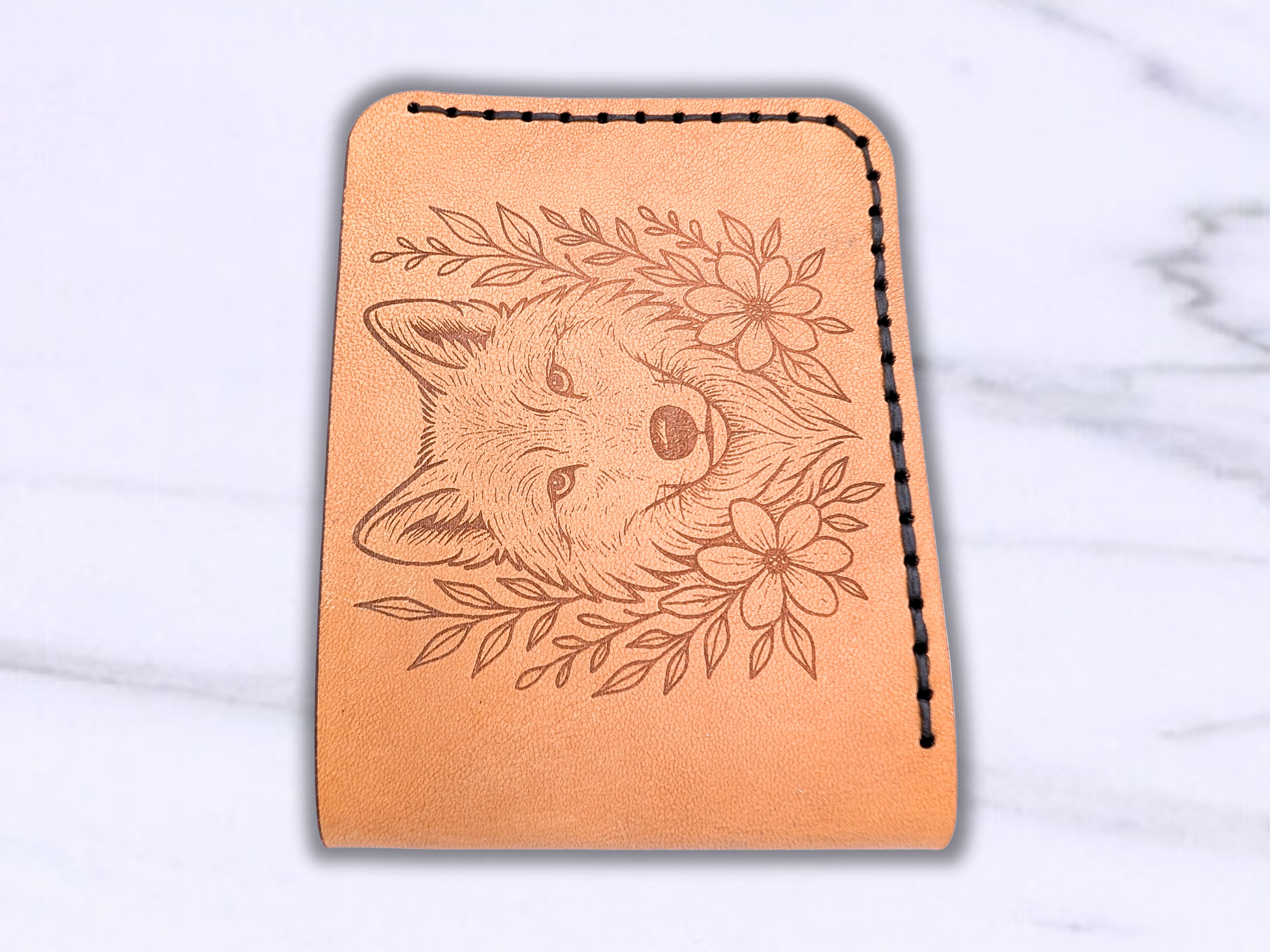 Wolf Bi Fold Hand sewn wallet laying flat with the folded edge to the front of the photo. 