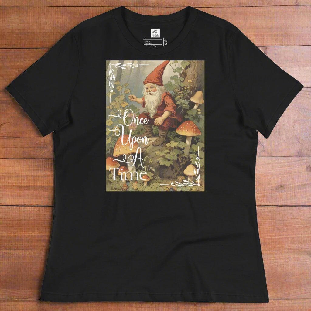 flat front of a women's relaxed black t-shirt. Graphic features a vintage 1800s image from a fairy tale of a gnome sitting in a forest surrounded by mushrooms telling tales holding a pipe. Once Upon A Time text on graphic.