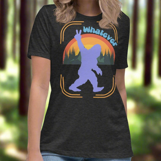 Dark Grey Sasquatch Women's T-Shirt. Big Foot in periwinkle against a rainbow and mountains showing a peace sign with text Whatever. Bigfoot Yeti Women's Tee