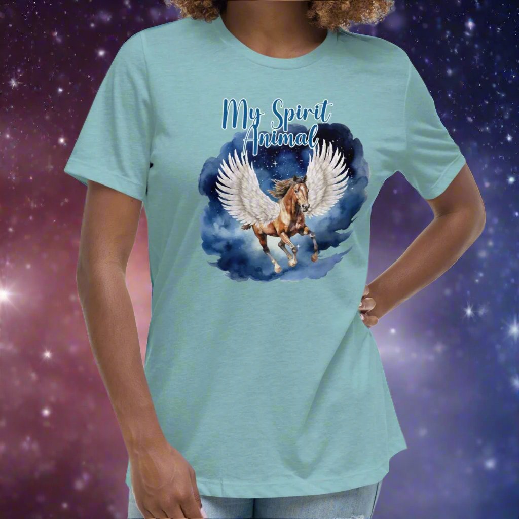 My Spirit Animal Women's Graphic Tee, front view heather blue lagoon, Pegasus white feathered wings on a Pinto with a dark brown mane and tail, galloping through the sky against a background of clouds and stars. Mythical Accessories