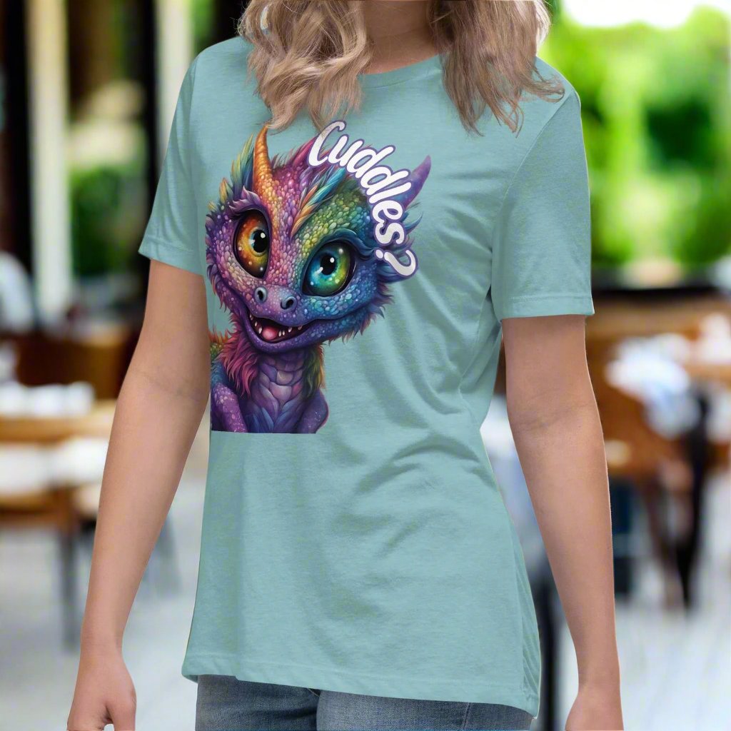 heather blue lagoon Dragon Cuddles left Front View Women's T-Shirt. Whimsical purple iridescent  dragon looking up at the word Cuddles? above his head