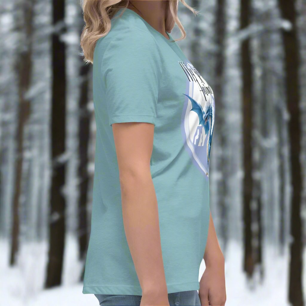 My Spirit Animal Dragon Women's Graphic Tee, right side view of blue lagoon shirt, Blue Ice Dragon with wings spread standing in front of snow capped mountain range with a dragon silhouette flying above within a blue grey circle