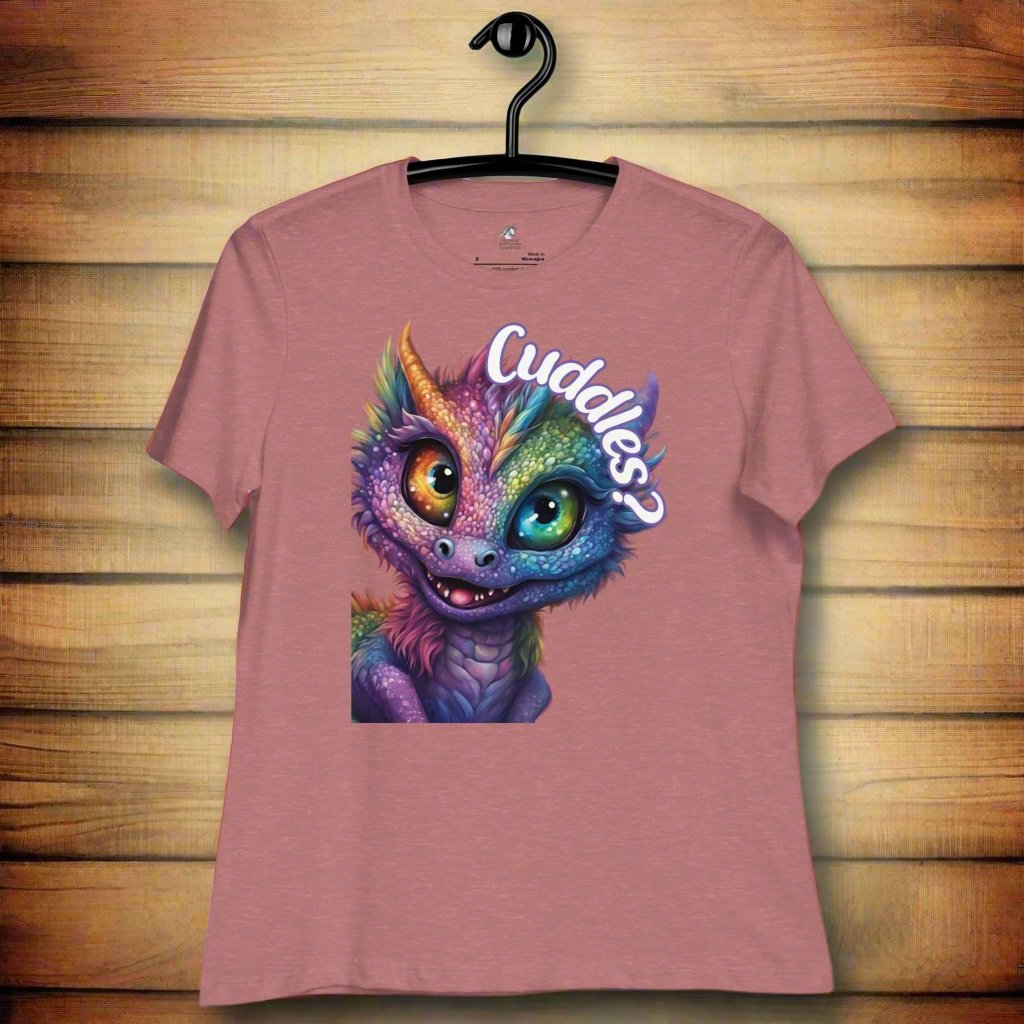 heather mauve Dragon Cuddles Front View Women's T-Shirt on hanger. Whimsical purple iridescent  dragon looking up at the word Cuddles? above his head