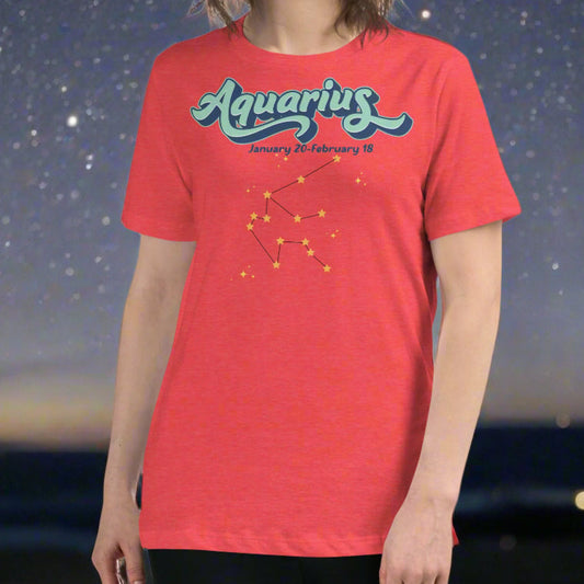 Woman in a heather red astrology Aquarius T-shirt facing forward. At the top in light blue is the word Aquarius outlined in deeper blue. Below this it says January 20- February 18. Under this is the Aquarius constellation with orange yellow stars connected by a black line. Astrology Zodiac Aquarius Woman's Tee
