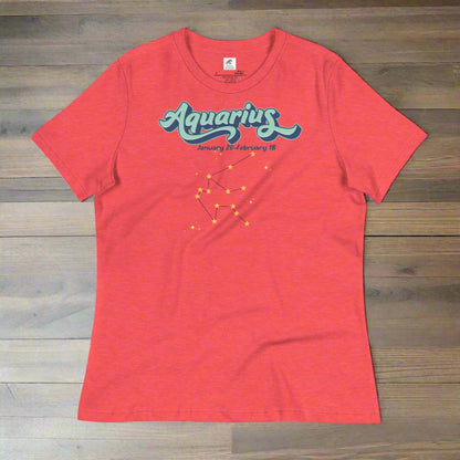 Flat lay heather red astrology Aquarius women's T-shirt on a wooden counter. At the top in light blue is the word Aquarius outlined in deeper blue. Below this it says January 20- February 18. Under this is the Aquarius constellation with orange yellow stars connected by a black line. Astrology Zodiac Aquarius Woman's Tee